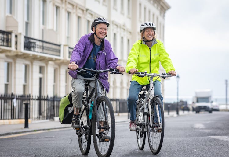 Smiling Women On Bikes On Street