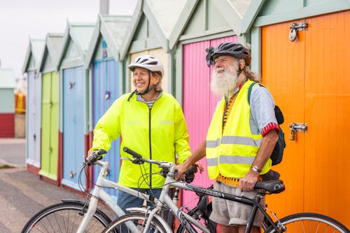 Elderly Couple with Bicycles Near the Beach Huts