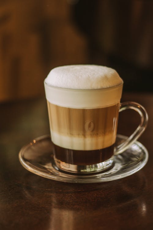 Free A coffee cup with foam on top sitting on a saucer Stock Photo