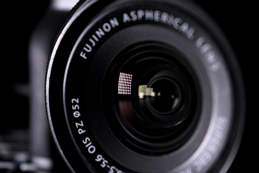Detailed close-up image of a Fujinon aspherical camera lens with reflections.