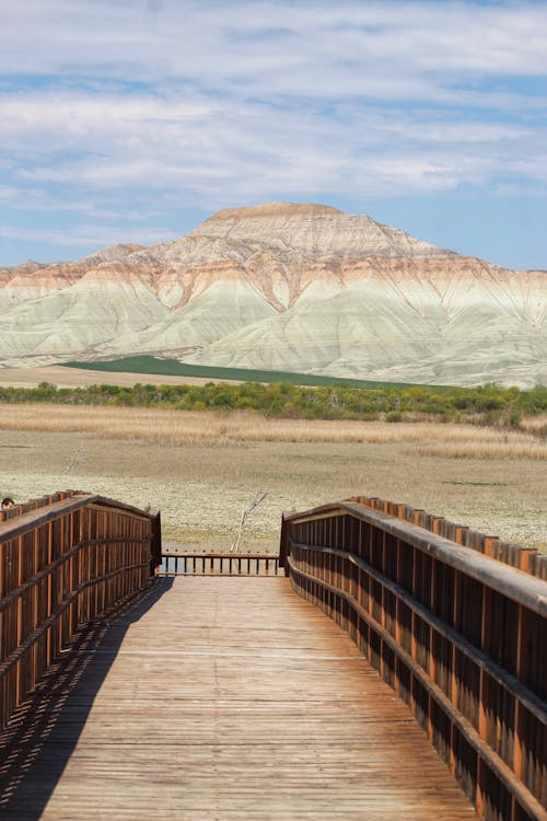 Free A wooden bridge over a river with mountains in the background Stock Photo