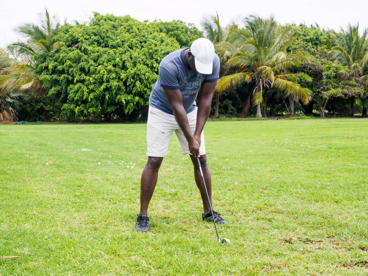Golfer preparing to hit a golf ball on a lush green course