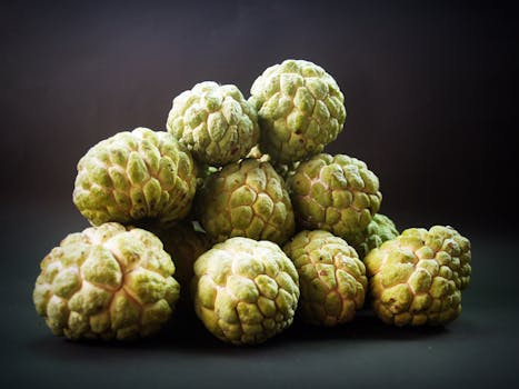 Bright green custard apples displayed against a dark background.