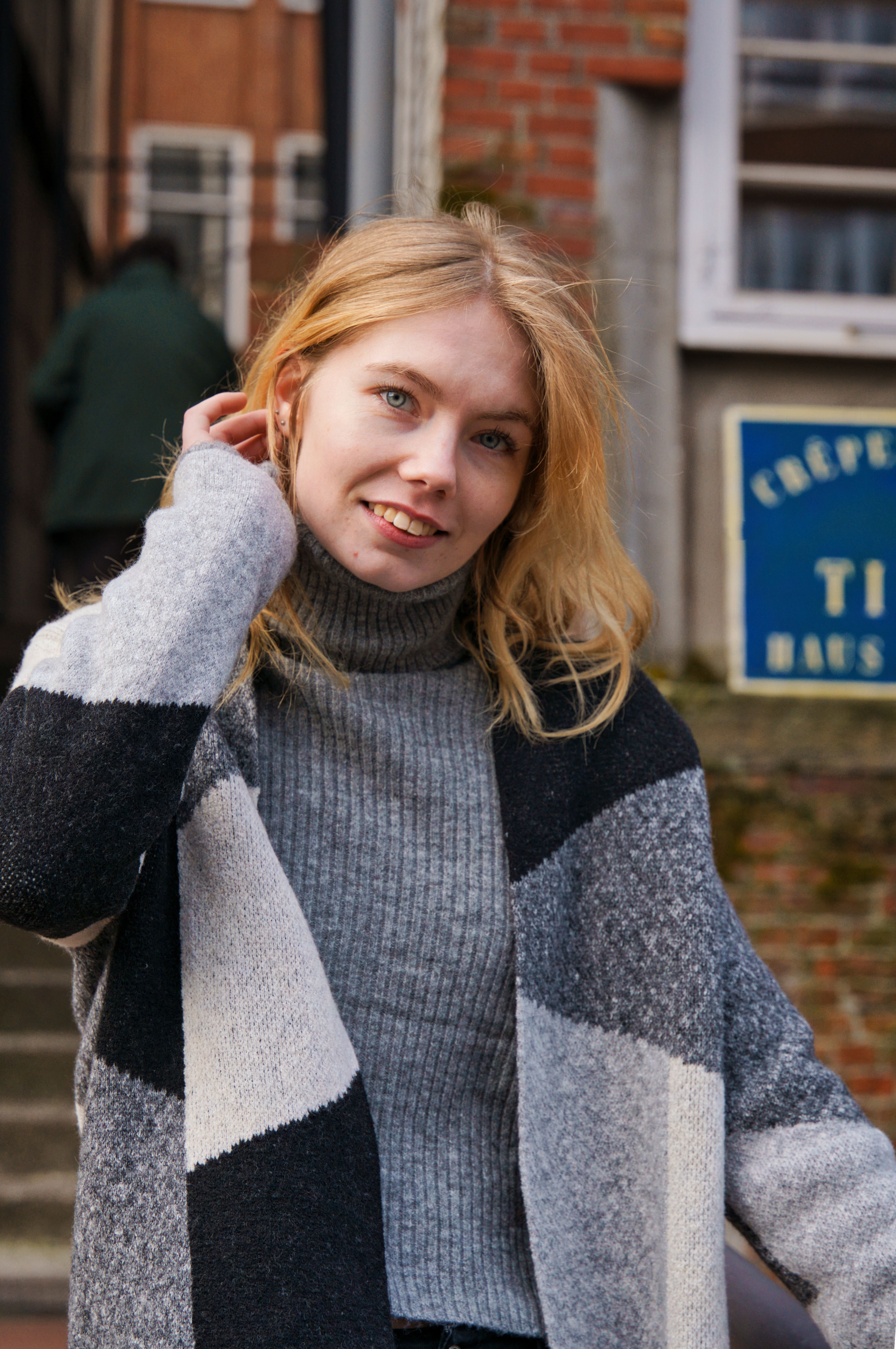 Captivating portrait of a woman in a gray turtleneck sweater outdoors in Hamburg.