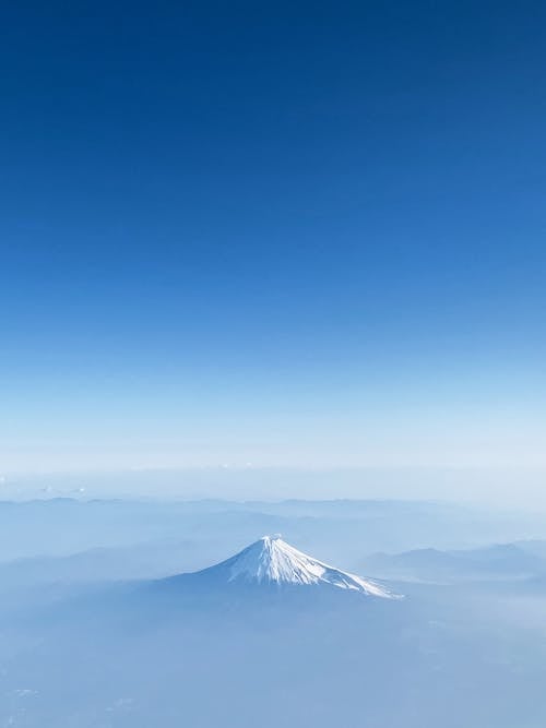 bulutların üstünde, dağ, dikey atış içeren Ücretsiz stok fotoğraf