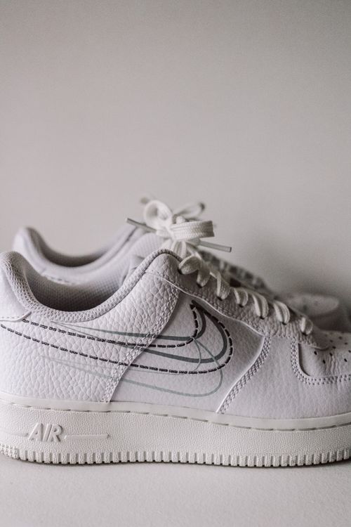 Free Pair of white sports shoes with shoelaces on a plain background. Stock Photo