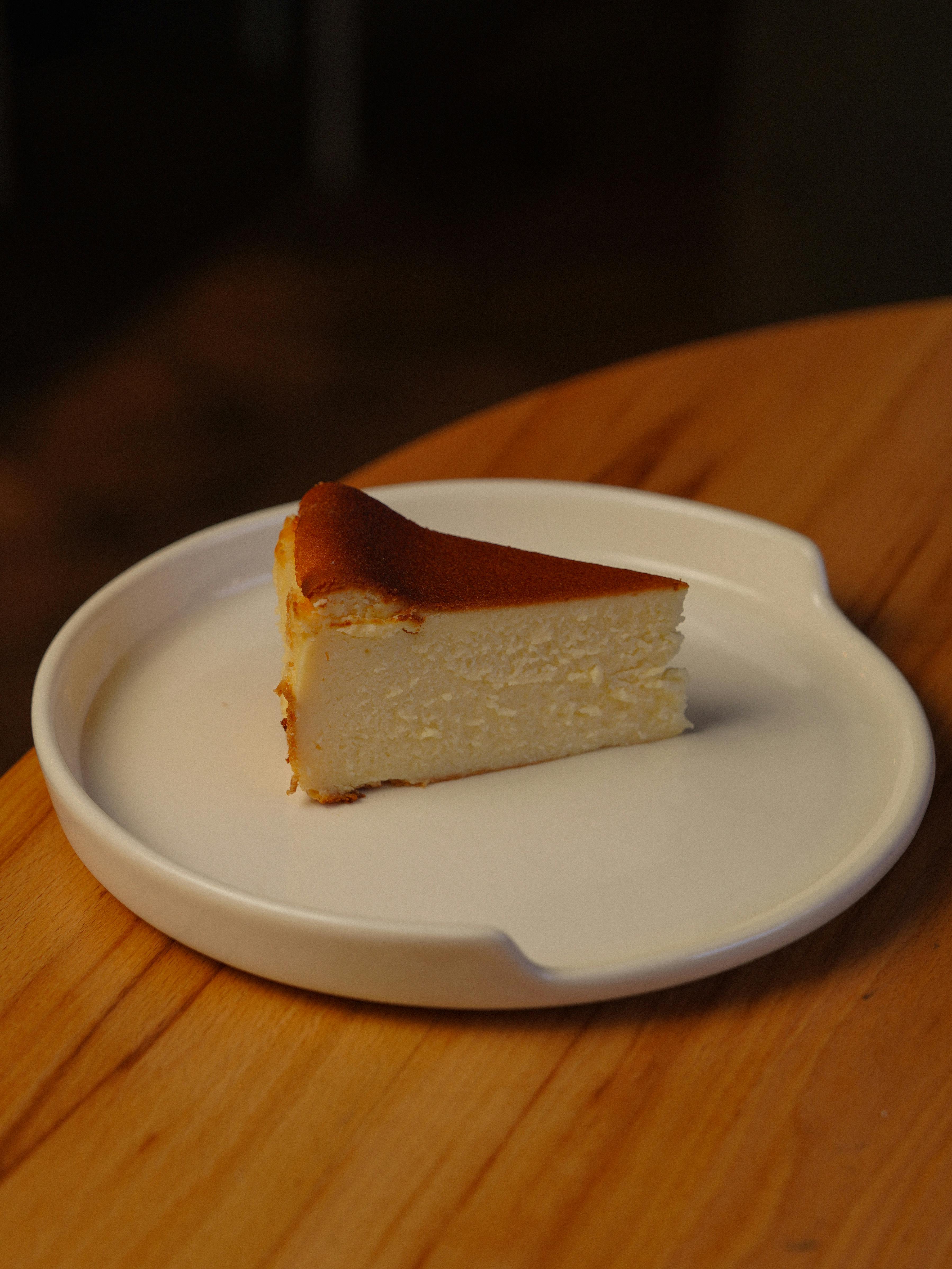 Close-up of a delicious piece of cheesecake on a white plate, perfect for dessert lovers.