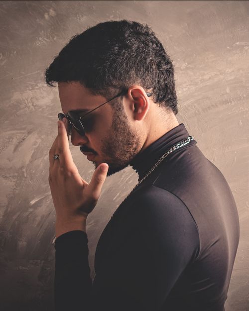 Free Fashion portrait of a young man in black turtleneck and sunglasses with a contemplative pose. Stock Photo