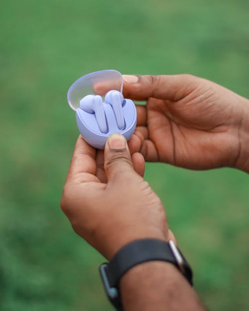 A person holding a small blue object in their hand