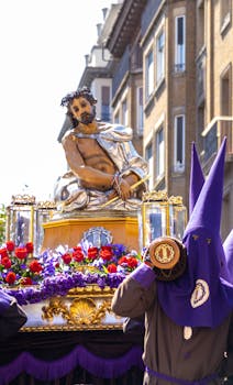 Easter procession in Zaragoza with statues and participants in vibrant costumes.