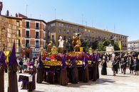 A vibrant religious procession with costumes and statues in Zaragoza, Spain.
