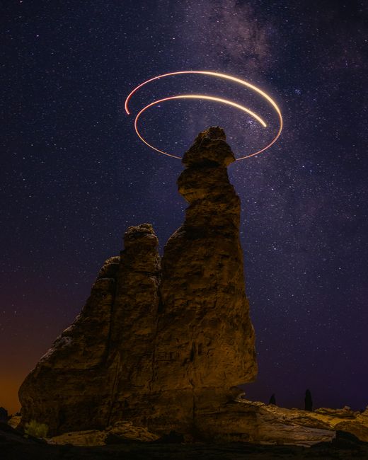 A mesmerizing night sky over a rock formation in AlUla, Saudi Arabia with star trails.
