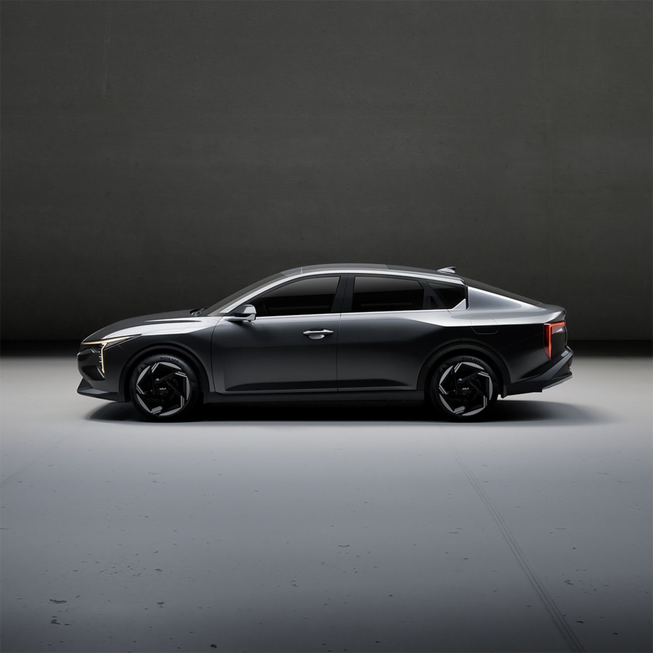 Dark grey electric performance sedan in a minimal studio