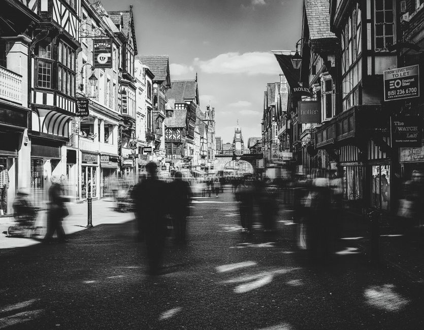 Dynamic black and white city scene capturing Chester's iconic architecture and bustling streets.