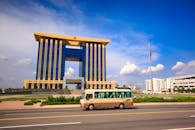 蔚蓝的天空下，一座引人注目的现代化办公楼前，公交车驶过，国旗飘扬