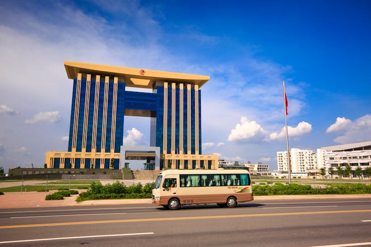 Bus On Road Near Brown And Blue Building