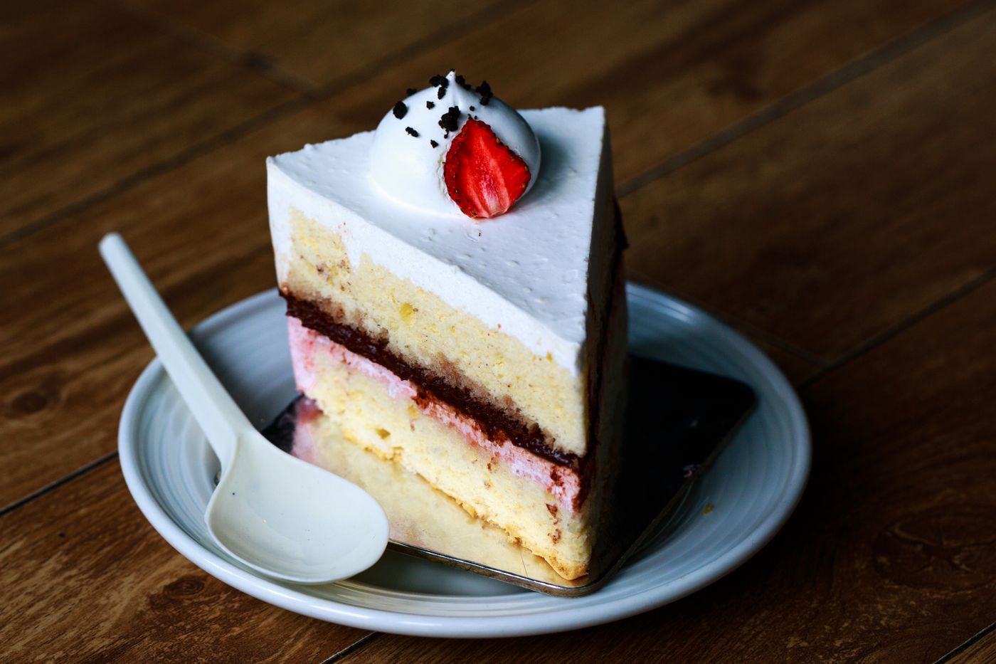 A layered cake slice with strawberry