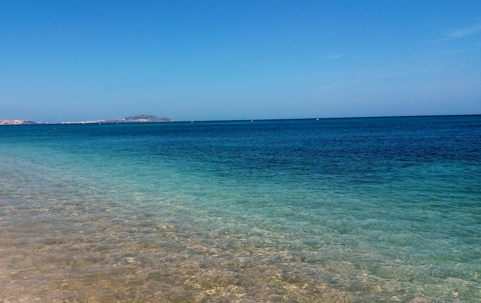 Beautiful tranquil beach in Morocco with turquoise water and clear horizon, perfect for a relaxing summer vacation.