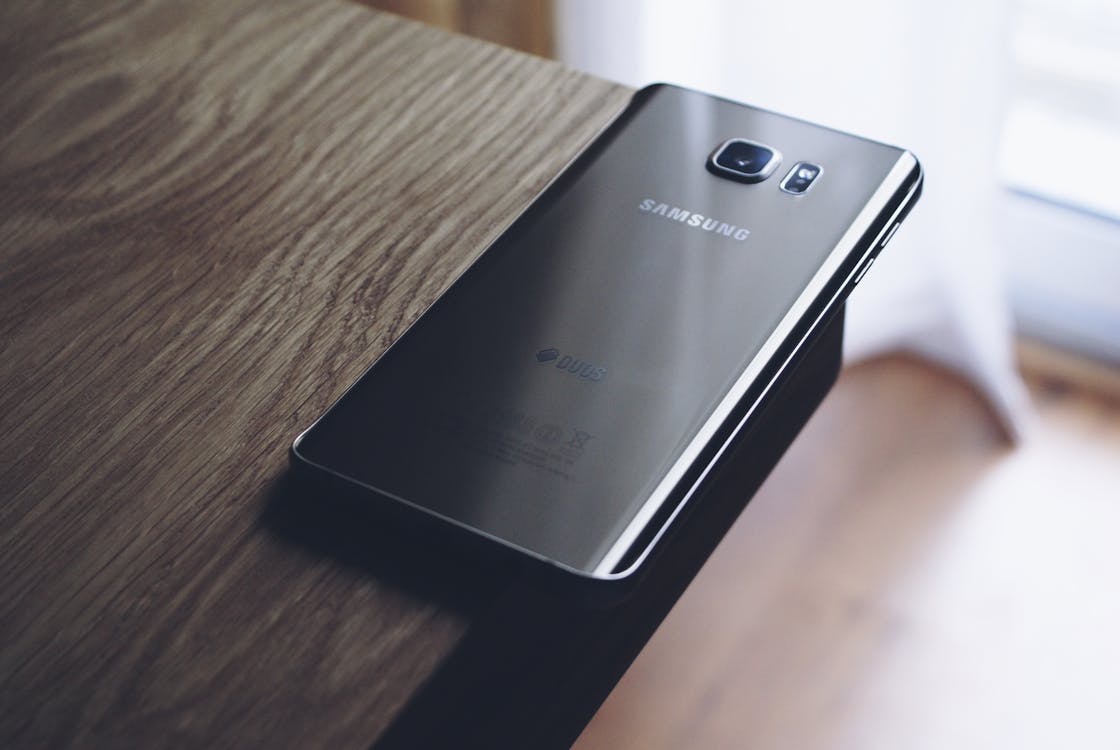grátis Smartphone Samsung Preto Android Em Cima De Uma Tábua De Madeira Marrom Foto profissional