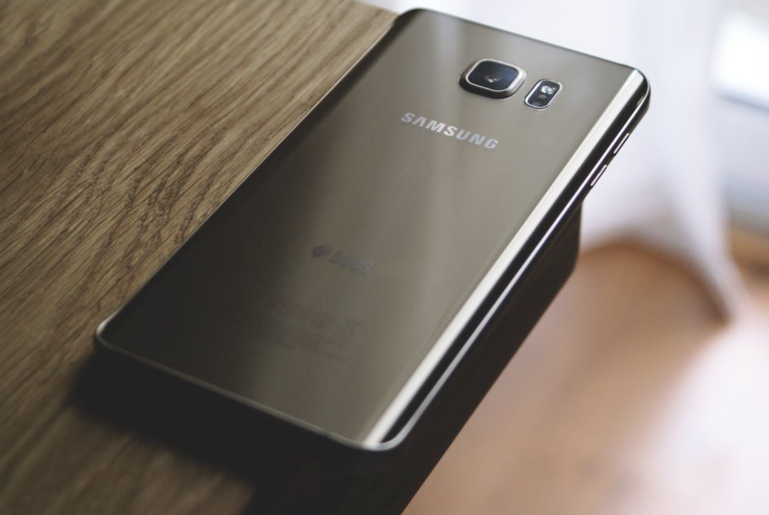 Miễn phí điện Thoại Thông Minh Samsung Galaxy Màu Bạc Trên đầu Bàn Gỗ Nâu Ảnh lưu trữ