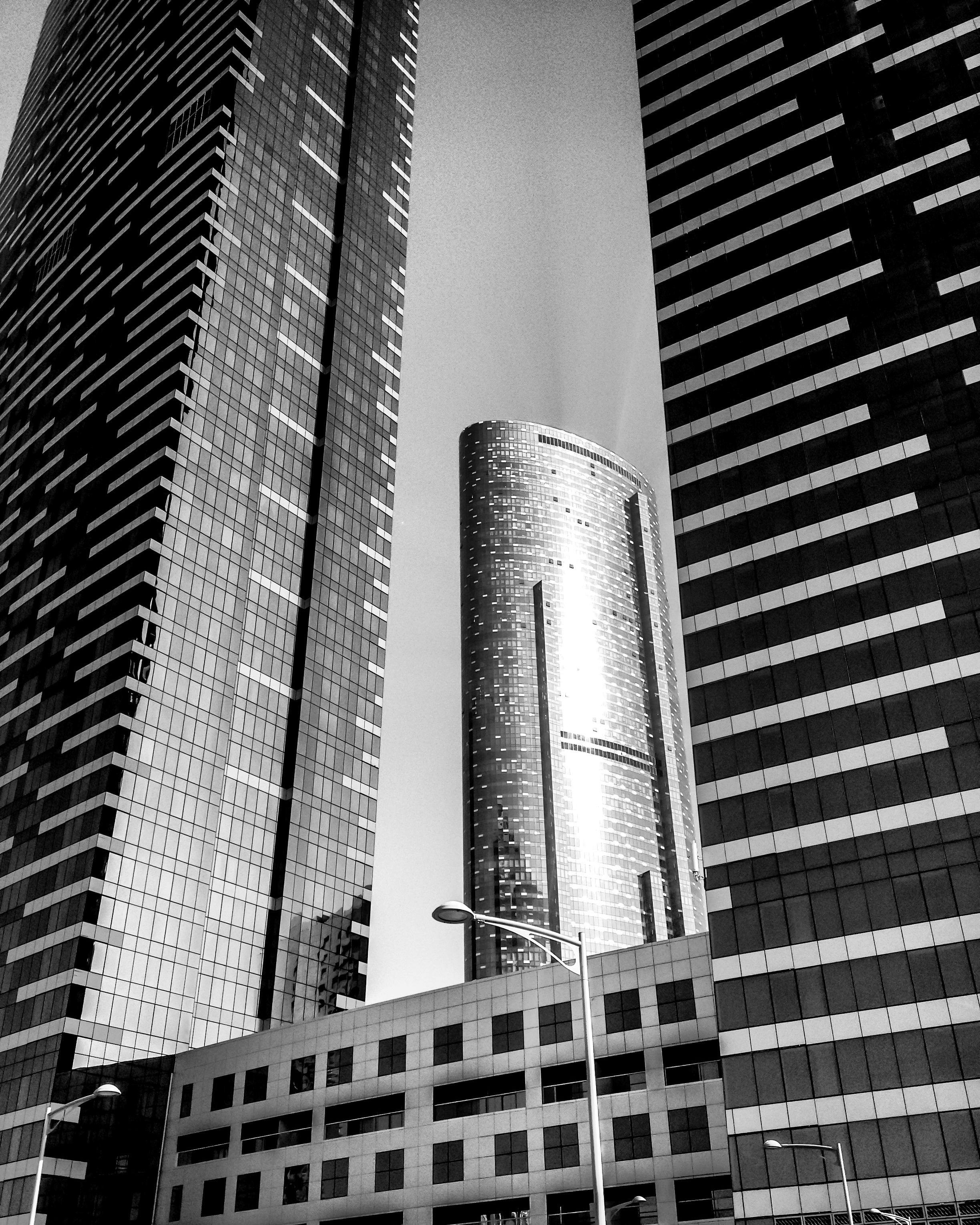 这张迪拜现代摩天大楼的黑白照片，突出了城市建筑及其倒影