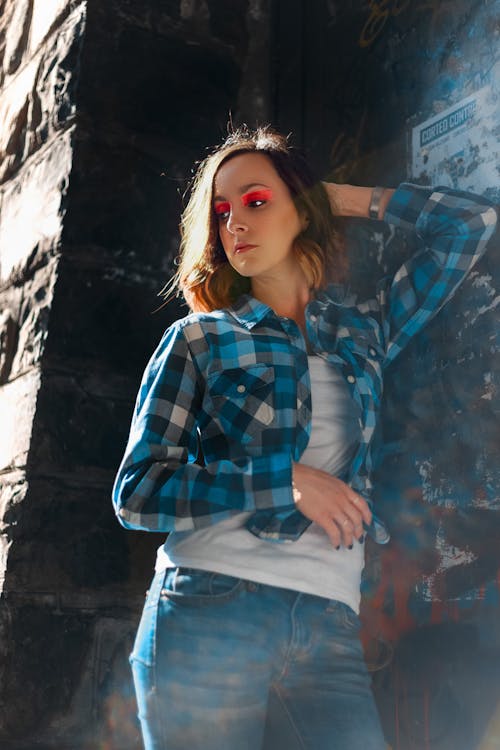 Photo of Woman in Blue and White Plaid Shirt and Blue Denim Jeans Posing