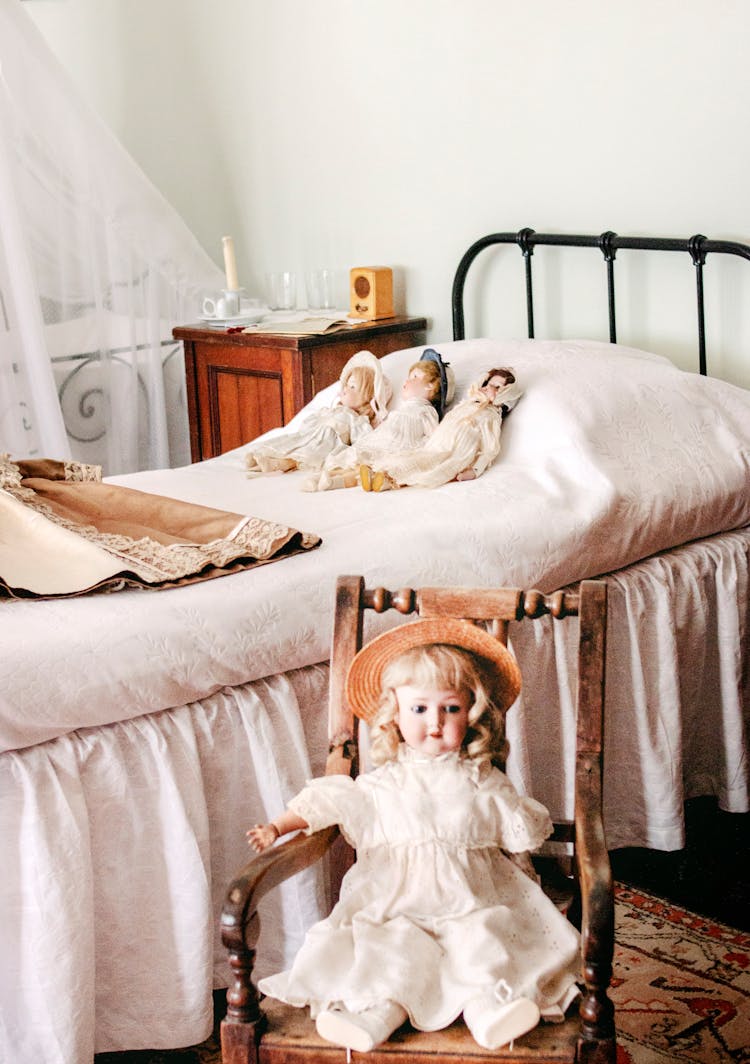 Three Dolls Lying On Bed