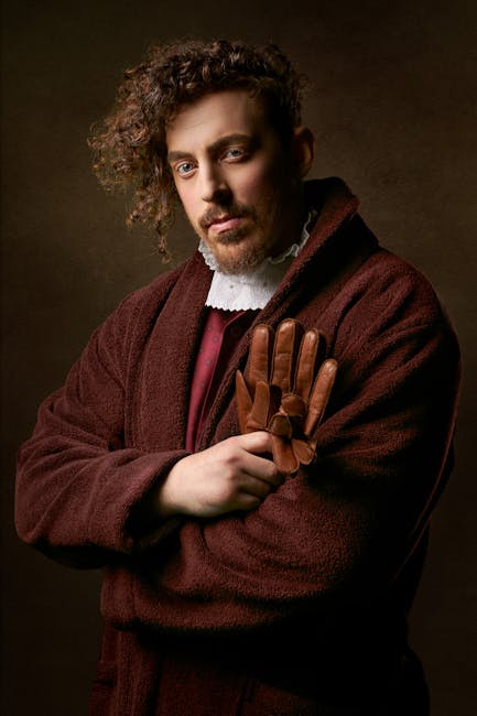 Classic portrait of a young man in vintage attire, holding gloves with a dramatic pose.