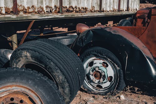 An old truck with a flat tire and a broken wheel