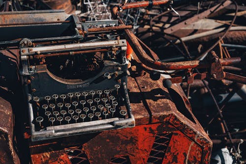 An old typewriter sitting on top of a pile of junk