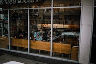 透过窗户，能看到热闹的咖啡馆里顾客往来，映出城市生活的气息