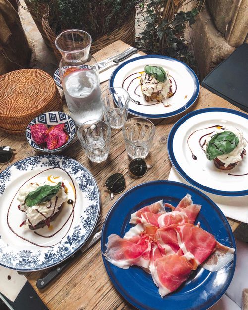 Free Charming table setting featuring prosciutto and elegant desserts, perfect for a delightful meal experience. Stock Photo