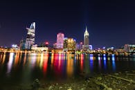 夜间，明亮的城市天际线倒映在水面上，展现出建筑的活力