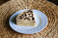 白色盘子里盛着一片咖啡味蛋糕，配以咖啡豆，非常适合甜点爱好者