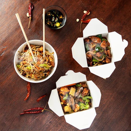 Chinese food in boxes on a wooden table