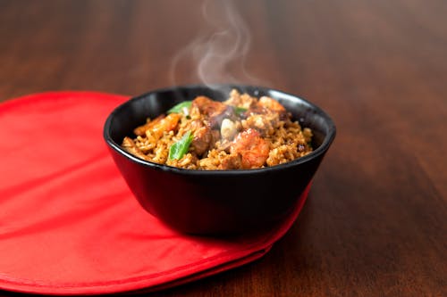 A bowl of rice with meat and vegetables