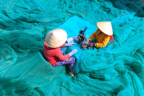 Person Sewing Blue Nets