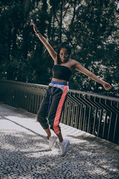 一位精力充沛的年轻女子在绿意环绕的桥上跳舞