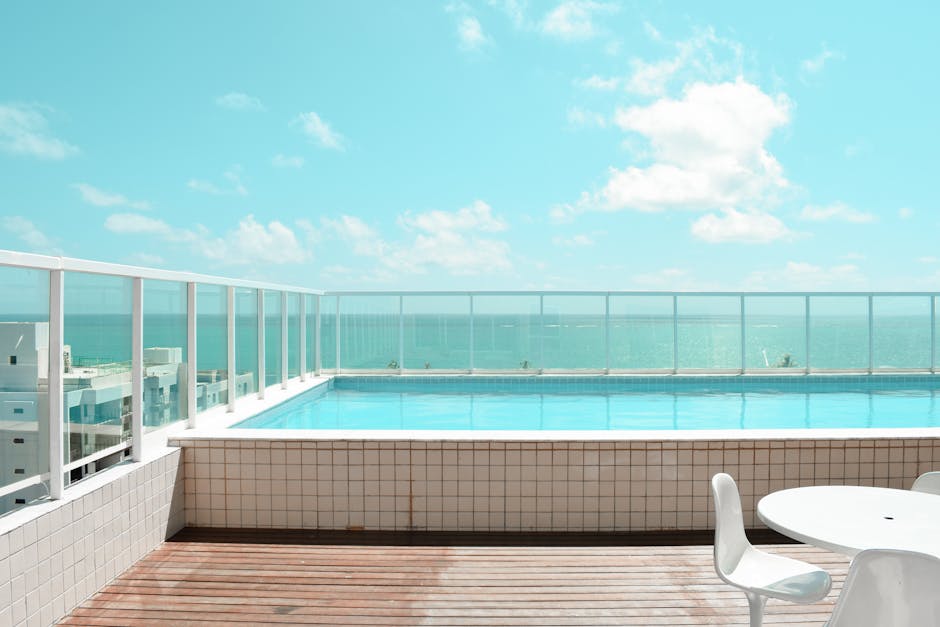 Serene rooftop infinity pool with stunning ocean view under a bright blue sky.