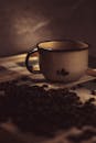 质朴的陶瓷杯与咖啡豆在黑暗中营造出温暖的环境