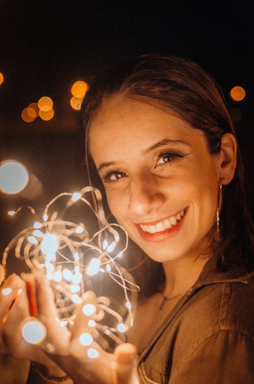 Free Smiling Woman Holding String Lights Stock Photo