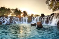 日落时分，瀑布周围的岩石和树木笼罩在宁静之中