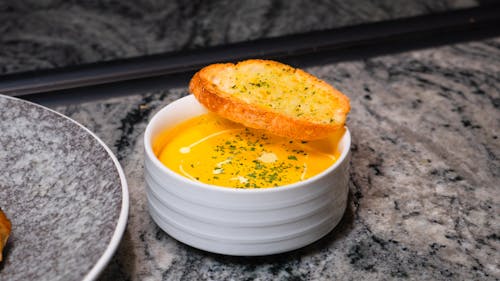 Free A bowl of soup with bread on top of it Stock Photo