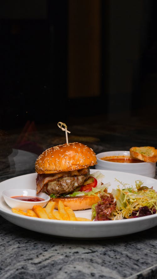 Free A burger and fries on a plate with a glass of beer Stock Photo