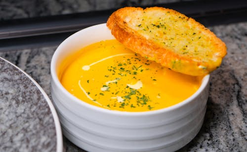 Free A bowl of soup with bread on top Stock Photo
