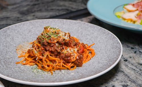 A plate of spaghetti and meat on a table