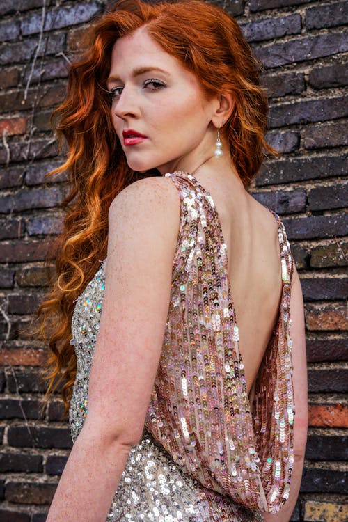 A woman with red hair and a sequin dress