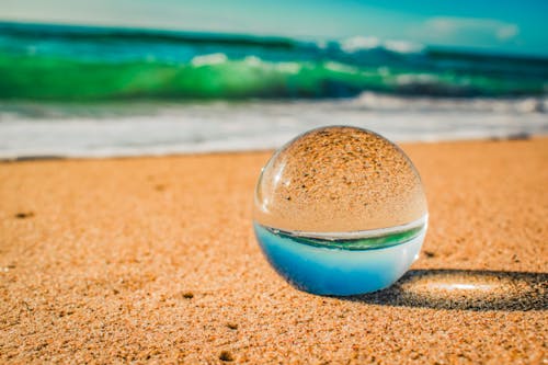 Close-Up Photo Of Crystal Ball On Sand 
