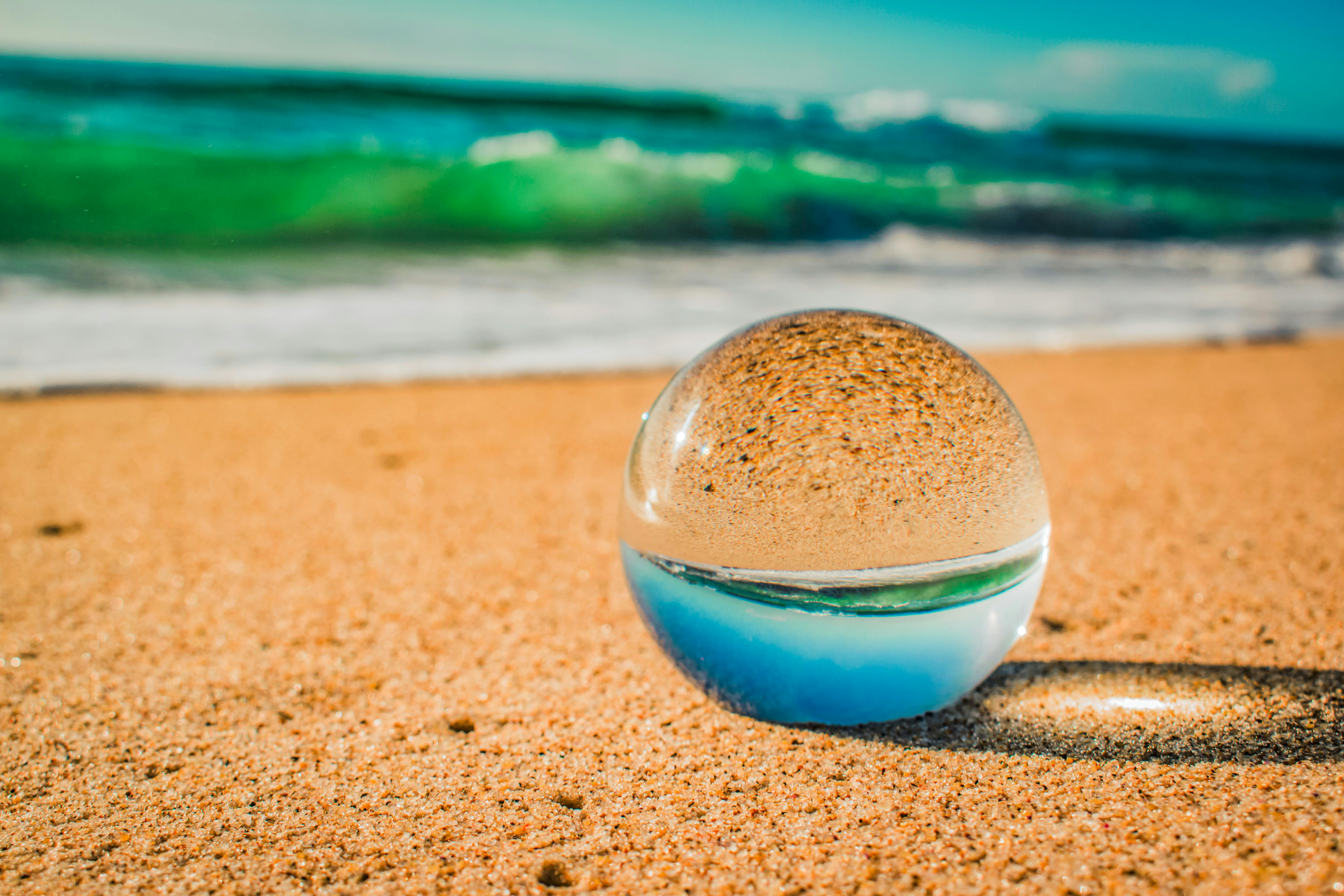 CloseUp Photo Of Crystal Ball On Sand · Free Stock Photo
