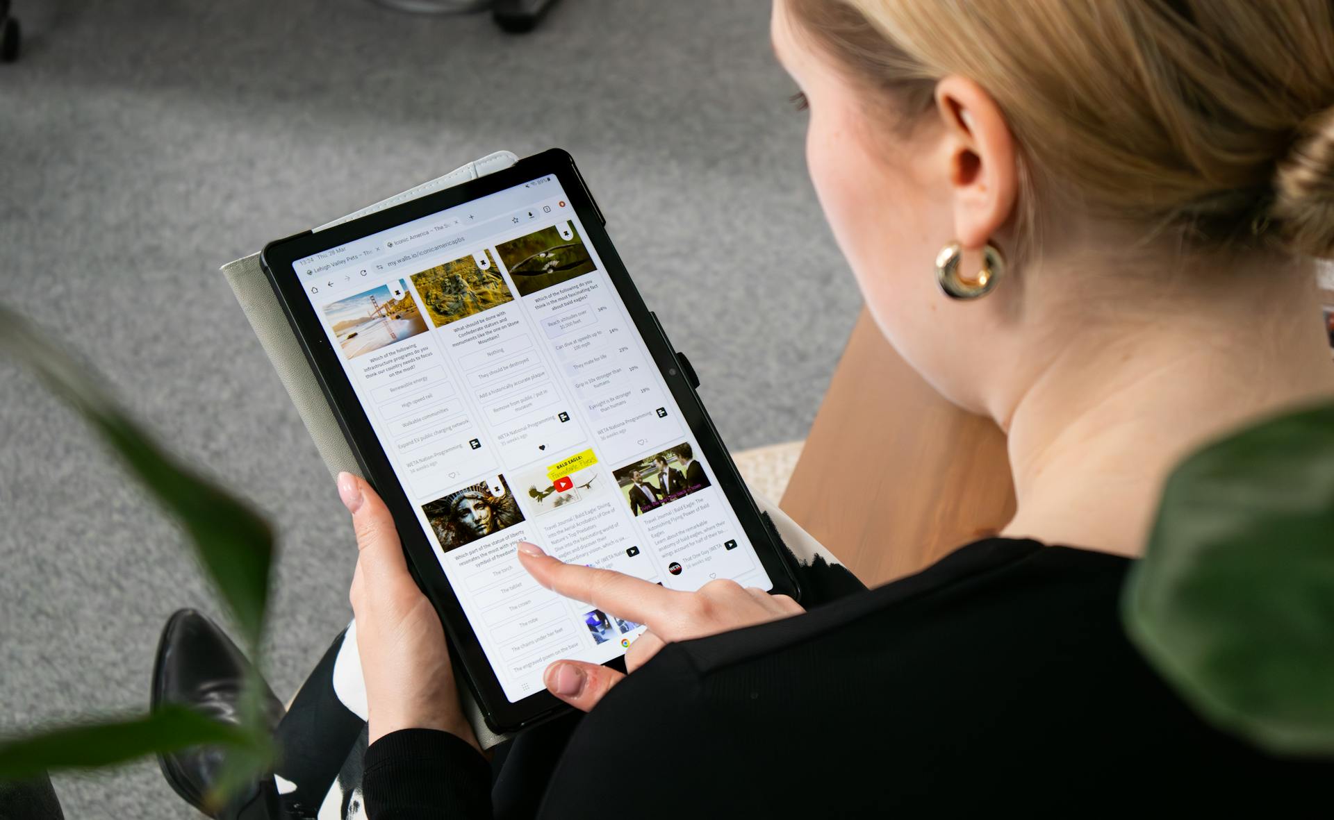 A woman browsing the web on a tablet, sitting in an office environment